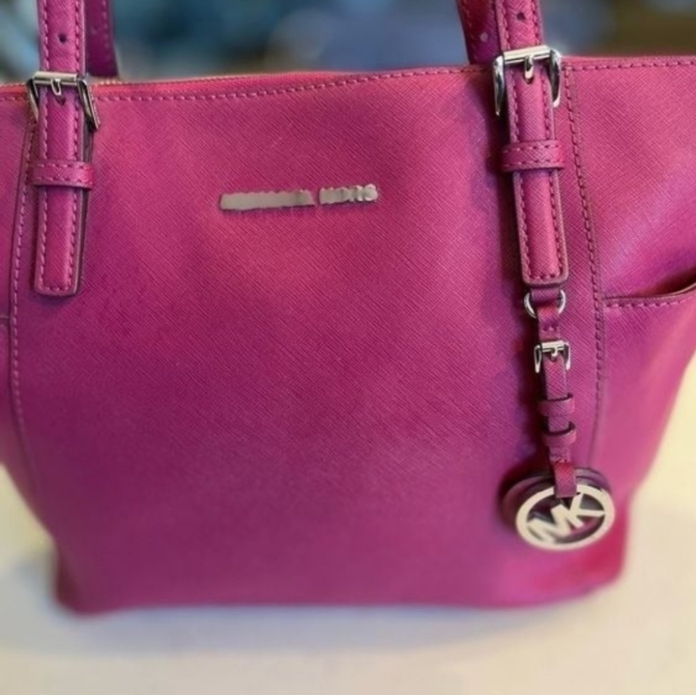 This is a wild berry pink east west jet set tote. Gold hardware.